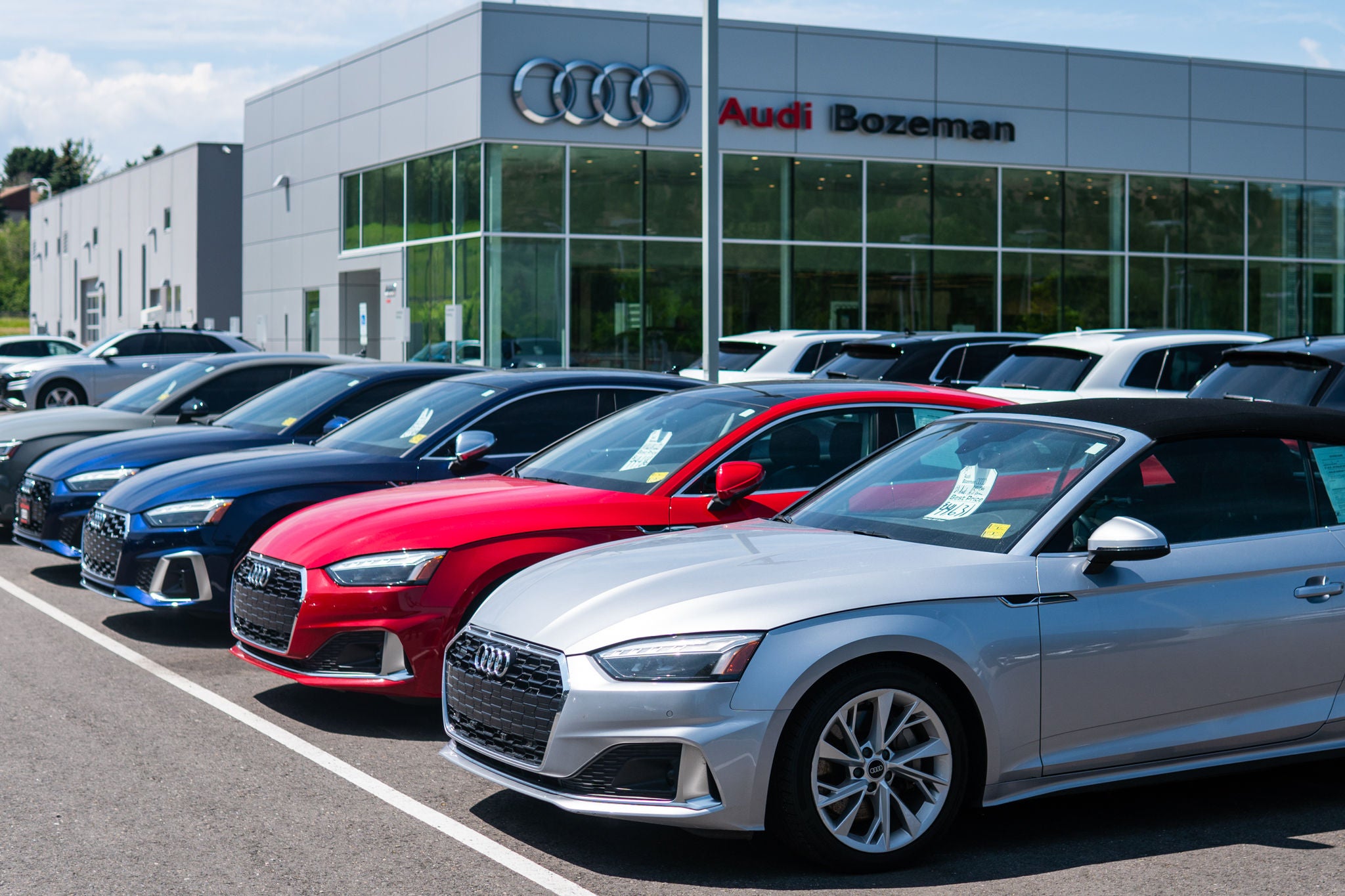 Used and Certified pre-owned Audi sedans parked outside at the Audi Bozeman parking lot